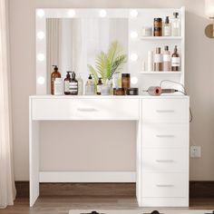 a white vanity with lighted lights and bottles on it