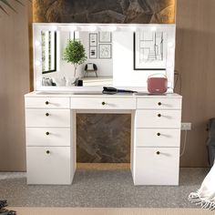 a white desk with two mirrors and a plant on it in front of a stone wall