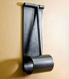 a toilet paper dispenser mounted to the side of a wall with a metal handle