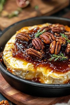 a baked cheesecake with pecans and caramel sauce in a cast iron skillet