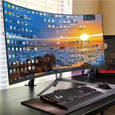 a computer monitor and keyboard sitting on top of a desk next to each other in front of a window