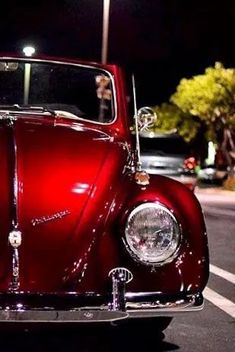 an old red car is parked on the street