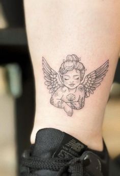 a small tattoo on the ankle of a woman's leg with an angel holding a flower