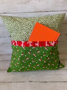 a green pillow with orange and red fabric