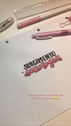 a pink pen sitting on top of a piece of paper