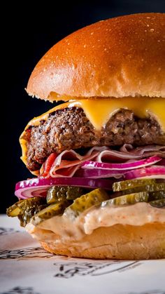 a cheeseburger with pickles and onions on a bun