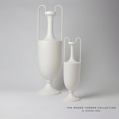 two white vases sitting next to each other