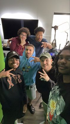 a group of young men standing next to each other in front of a computer screen