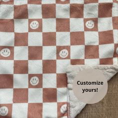 a red and white checkered blanket with smiley faces on it that says customize your