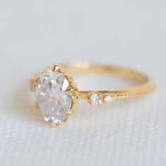 a close up view of a diamond ring on a white surface