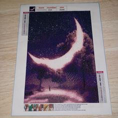 a cross stitch picture of a crescent moon in the night sky