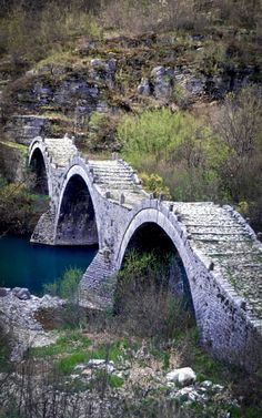 an old stone bridge over a small river