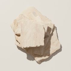 three pieces of white rock sitting on top of each other in front of a white background