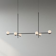 three lights are hanging from the ceiling in a room with gray walls and flooring