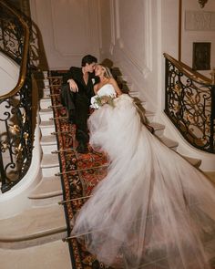 a bride and groom are sitting on the stairs