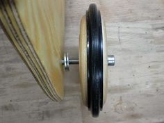 a close up of a wooden object on a wood floor with metal knobs and screws