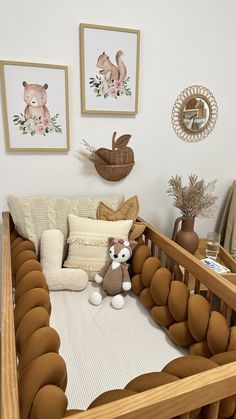 a baby crib with stuffed animals and pillows on it's bed in a nursery