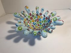 a colorful glass bowl sitting on top of a table