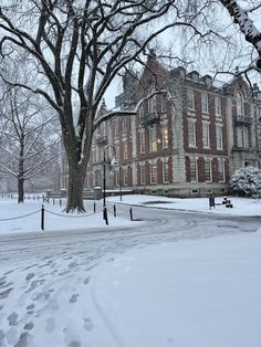 a large brick building surrounded by snow covered trees