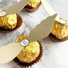 some cupcakes with gold foil on them