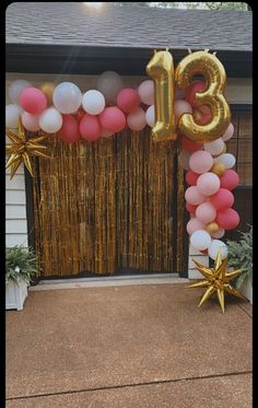 the entrance to a house decorated with balloons and streamers that spell out the number thirteen