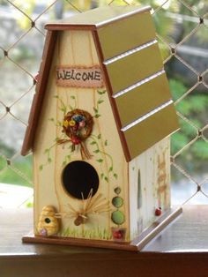 a wooden birdhouse with welcome written on it