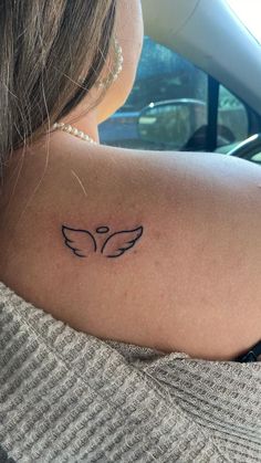 a woman with a tattoo on her back shoulder and the word love is written in black ink