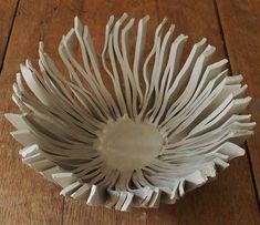 a white vase sitting on top of a wooden table