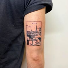 a person with a tattoo on their arm that has the eiffel tower in it