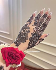 a woman's hand with henna on it and a flower in the middle