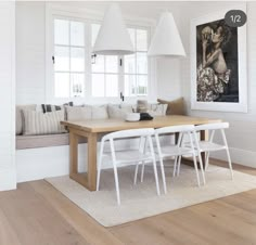 a dining room table with white chairs next to a couch