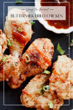 grilled chicken with sauce and green onions on a black plate next to dipping sauce