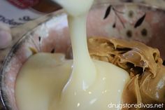 a spoon full of cream being poured into a bowl