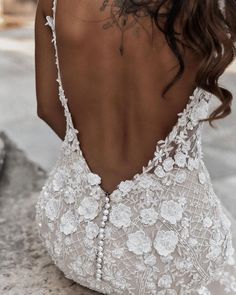 the back of a woman's wedding dress, with flowers and pearls on it