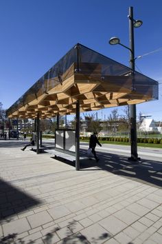 a person walking past a covered bus stop