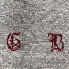 the letters e and f are embroidered onto linens with red stitching on them