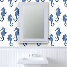 a bathroom with a mirror, sink and wallpaper that has seahorses on it