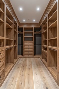 an empty walk - in closet with wooden shelves and drawers on both sides, lighting from the ceiling