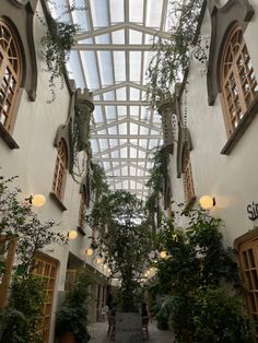 the inside of a building with lots of windows and plants growing on the walls in it