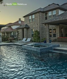 an outdoor swimming pool with lounge chairs and trees in the background at sunset or dawn