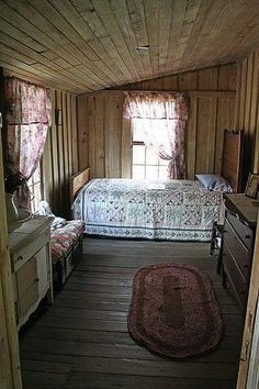 a bedroom with wood paneling and a bed in the corner next to a window