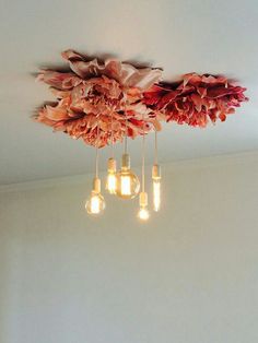 a chandelier with five lights hanging from it's sides and flowers on the ceiling