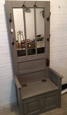 a gray bench with mirror on it in front of a white brick wall and floor