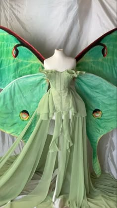 a green fairy dress with large wings on display