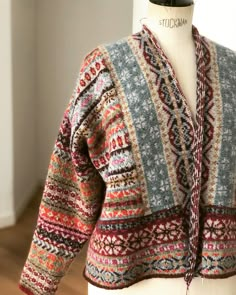 a mannequin wearing a multicolored cardigan sweater