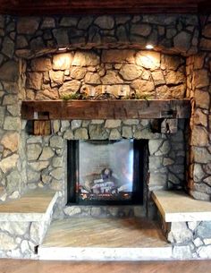 a stone fireplace with built in shelves and lights