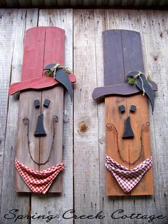 two wooden faces with hats and bandanas on them