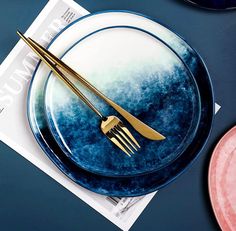 a blue and white plate with gold fork on it