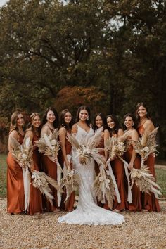 a group of women standing next to each other wearing dresses and holding bouquets in their hands