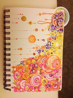 an open spiral notebook with colorful designs on it